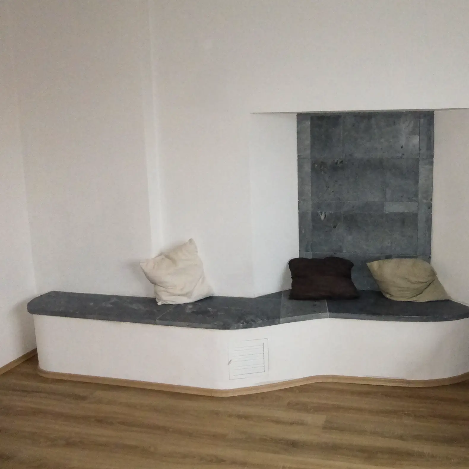 Rückseite desselben Specksteinofen mit beheizter Sitzbank für zusätzliche Strahlungswärme