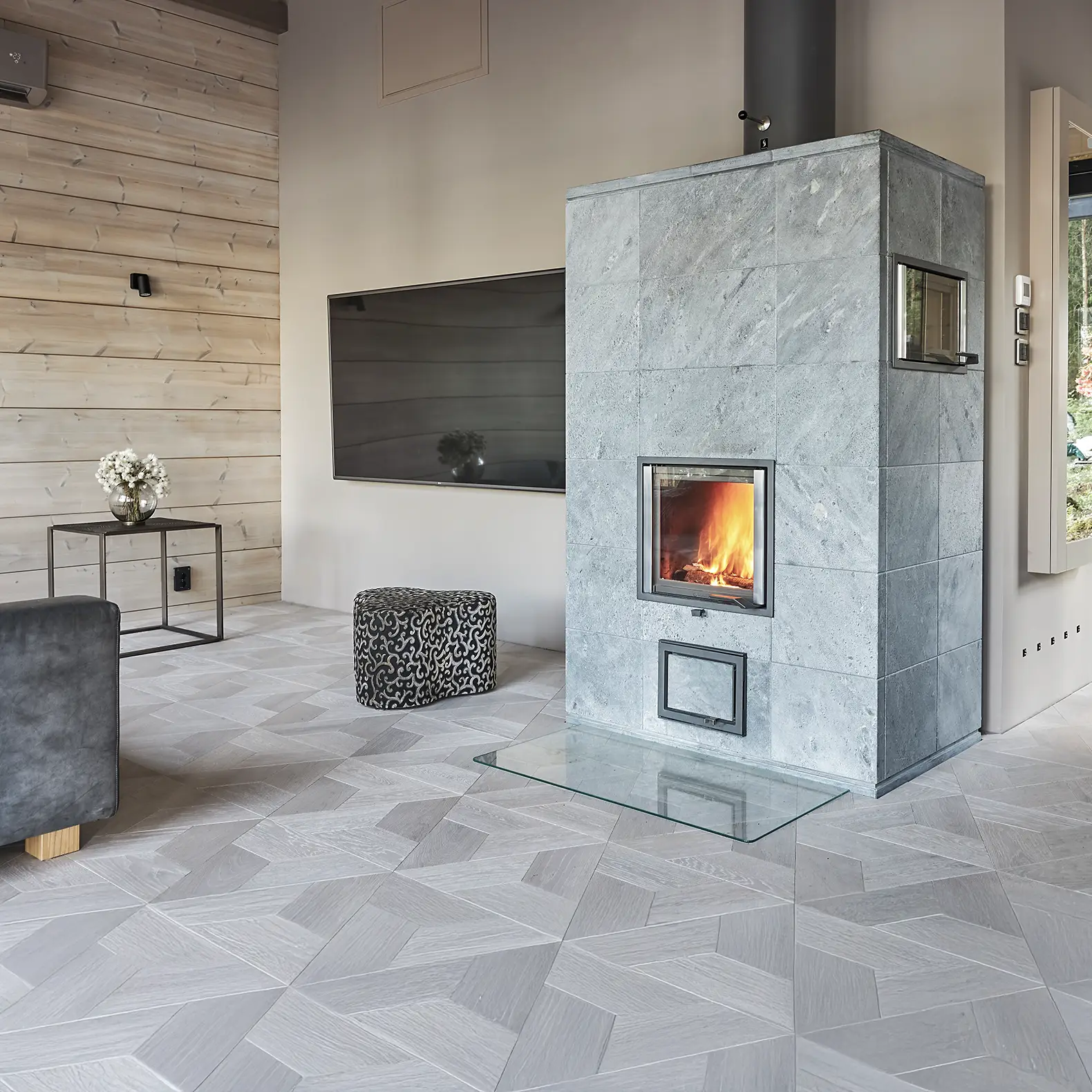 Kubischer Specksteinofen als zentrales Heizelement in modernem Wohnkonzept